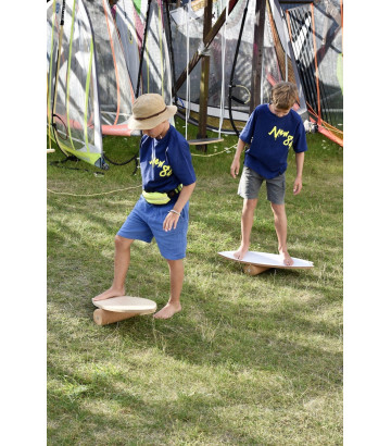 Ein Junge balanciert im Gras auf dem Wave Balance Board von NUKI