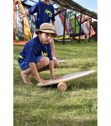 un niño haciendo equilibrio sobre la hierba en la tabla de equilibrio Wave de NUKI