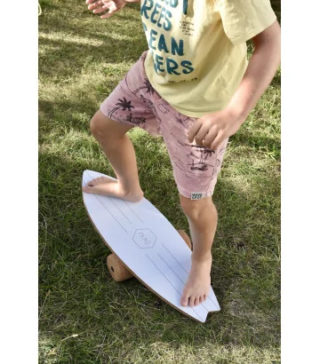 un niño haciendo equilibrio sobre la hierba en la tabla de equilibrio Wave de NUKI