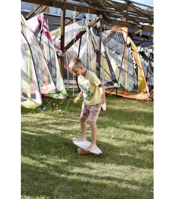 un niño haciendo equilibrio sobre la hierba en la tabla de equilibrio Wave de NUKI